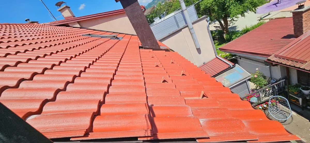 Învelitoare de țiglă roșie cu parazăpezi montate pe rând și coș îmbrăcat în tablă