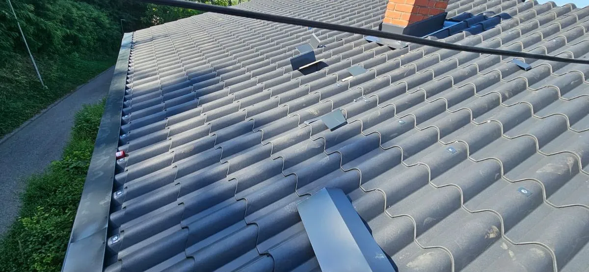 Țiglă metalică gri cu suporți și accesorii montate pe rânduri