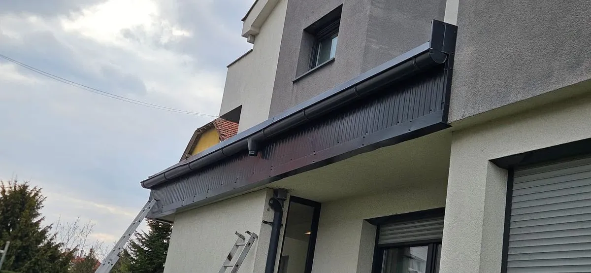 Streașină și jgheab finisate cu tablă antracit, pe o casă cu fațadă deschisă