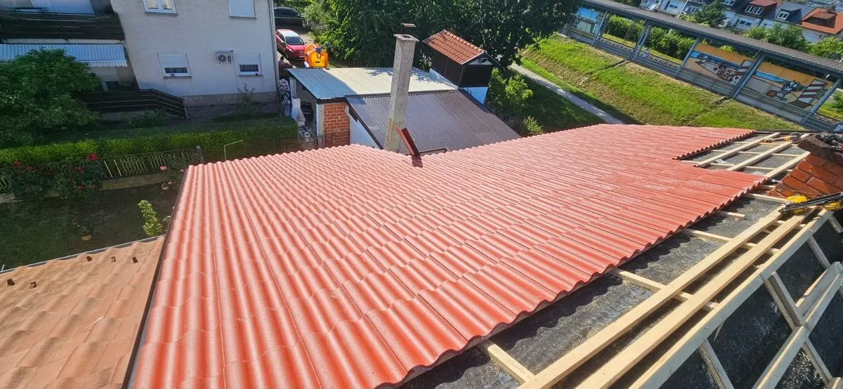 Acoperiș de țiglă roșie montat peste șipci, cu coșul de fum zidit